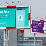 Two large outdoor billboards in an urban setting featuring a collaboration between Simpl and Zepto. The primary teal billboard asks, "kitne fast hain hum?" (How fast are we?), while the secondary purple billboard humorously references a popular meme with "mai kya job chhod doon?" (Should I leave my job?), promoting express checkouts for fast delivery services.