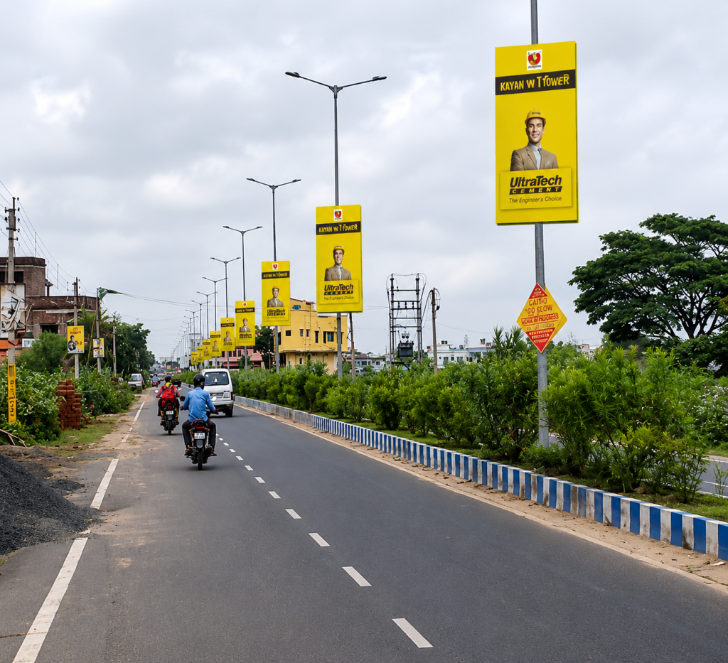 A series of lamp post banners line both sides of a roadway, creating continuous brand visibility for commuters and passing traffic. The street pole advertising format turns an entire stretch of road into a repetitive outdoor branding corridor, maximizing reach and recall.