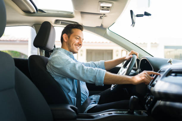 A man driving a car while adjusting the in-car audio system, representing radio advertising in India through audio promotions played during daily commutes. The image highlights the in-car listening experience commonly associated with FM radio and transit-based advertising reach.