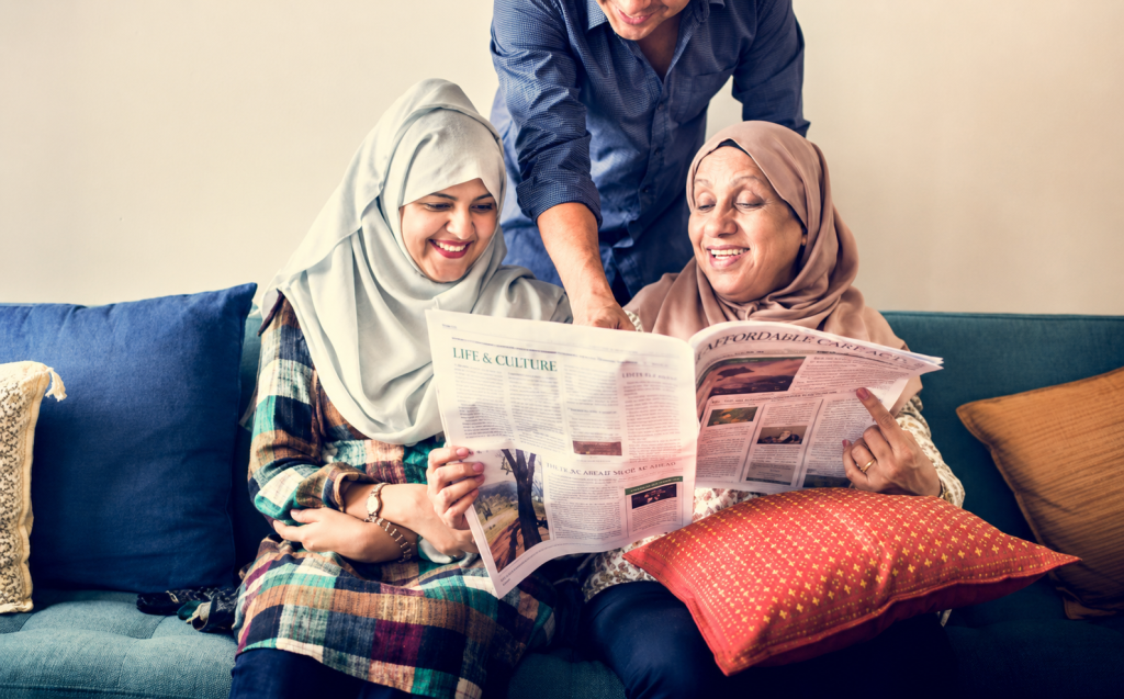 A family sitting together at home reading a newspaper, representing newspaper advertising and print media engagement in everyday households. The image highlights how newspaper advertisements and inserts reach readers during daily news consumption and family reading routines.
