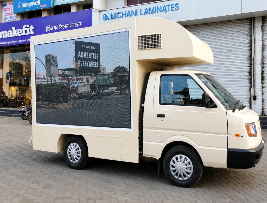 A digital outdoor mobile van advertising vehicle with a large LED display screen is parked on a commercial street for high-visibility brand promotions. The LED advertising van is designed for dynamic outdoor campaigns, mobile digital advertising, and roadshow marketing activations targeting busy urban audiences.